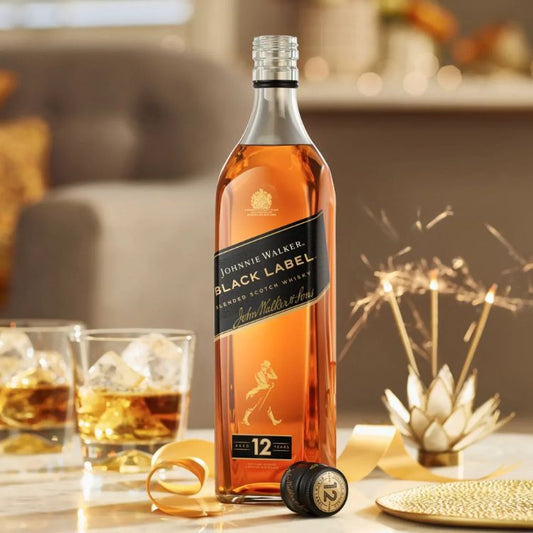 Johnnie Walker Black Label whisky bottle with glasses and decorative elements on a table.