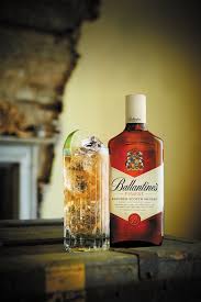 Ballantine's whiskey bottle with a cocktail on a wooden surface
