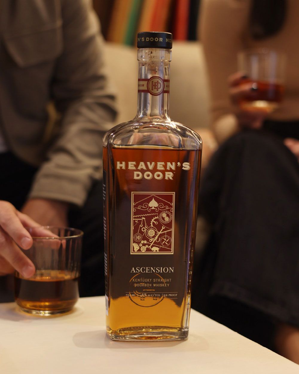 Bottle of Heaven's Door whiskey on a table with people in the background