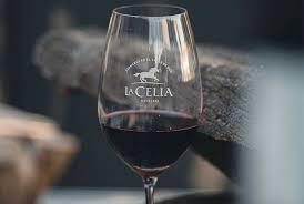 Wine glass with red wine and 'La Cecilia' branding on a blurred background